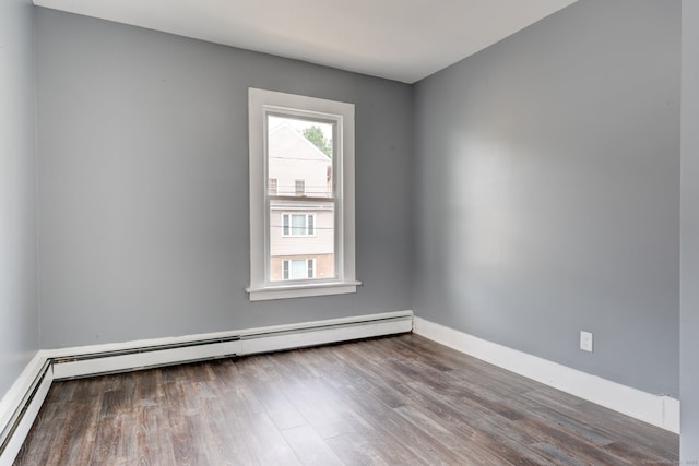 spare room featuring a baseboard radiator and hardwood / wood-style flooring