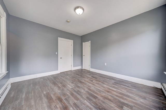 empty room with wood-type flooring and baseboard heating