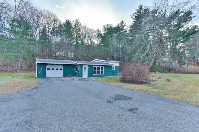 ranch-style house with a garage and a front lawn