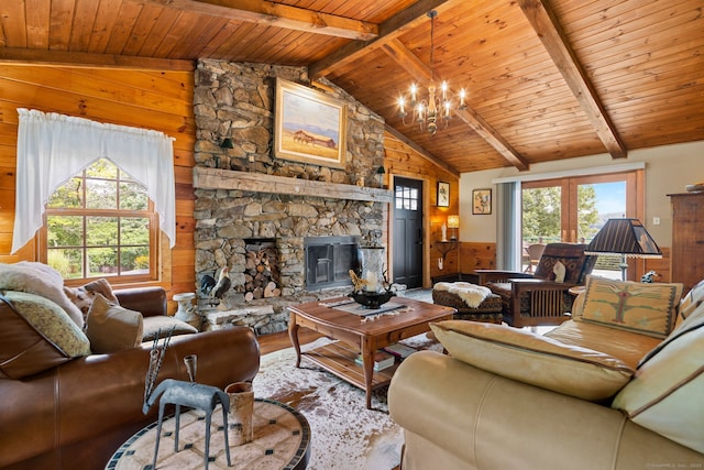 living room featuring an inviting chandelier, a stone fireplace, lofted ceiling with beams, wood walls, and wood ceiling