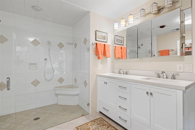 bathroom with tile patterned flooring, vanity, and walk in shower