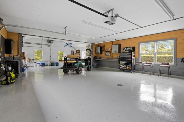 garage featuring wood walls and a garage door opener