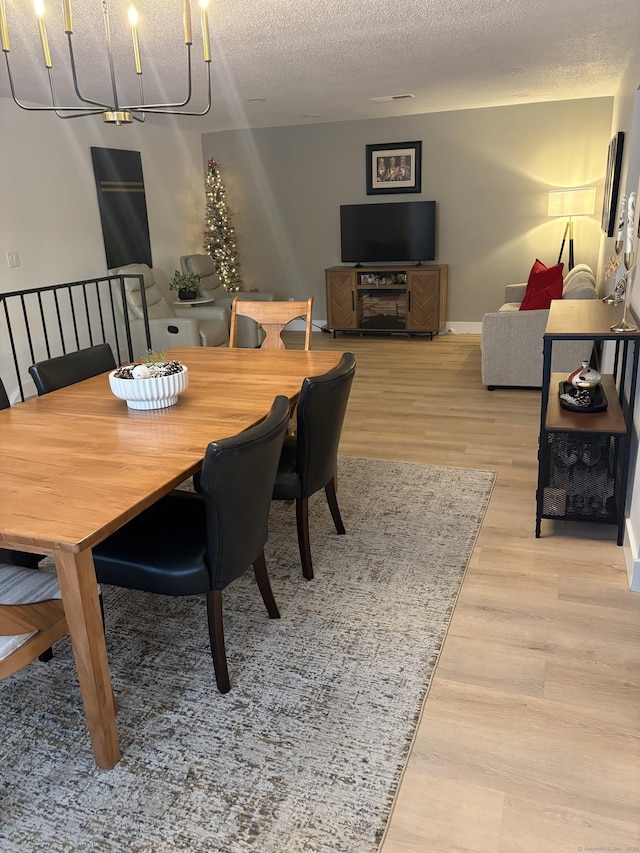 dining room featuring light hardwood / wood-style floors and a textured ceiling