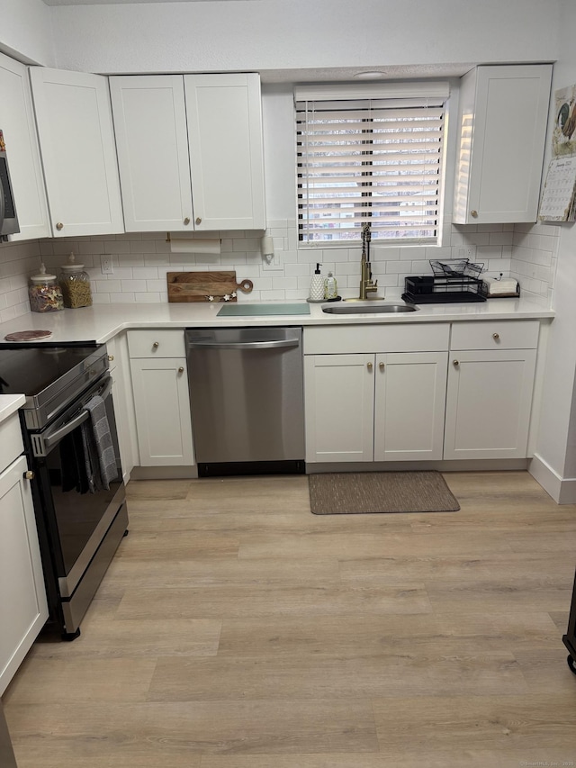 kitchen featuring white cabinets, stainless steel appliances, light hardwood / wood-style floors, and sink