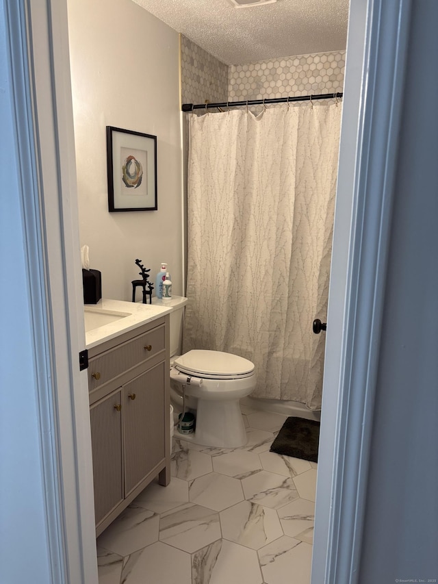 bathroom with vanity, a textured ceiling, and toilet