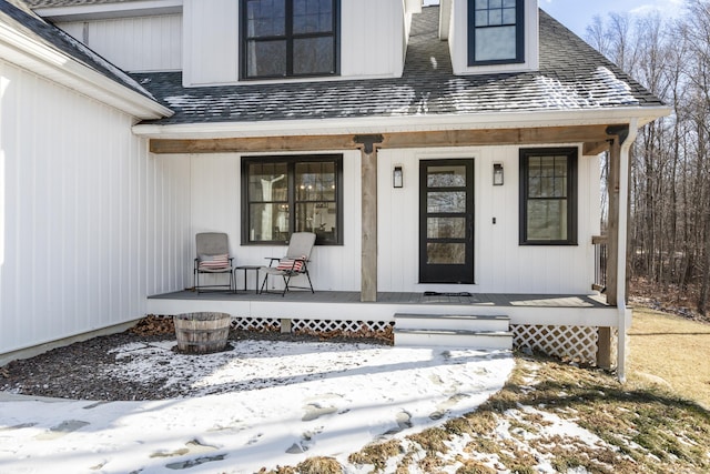 snow covered property entrance featuring a porch