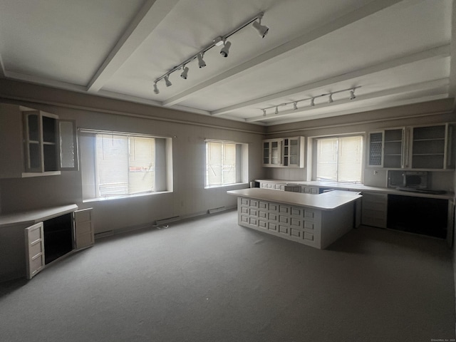 kitchen featuring beamed ceiling and carpet floors