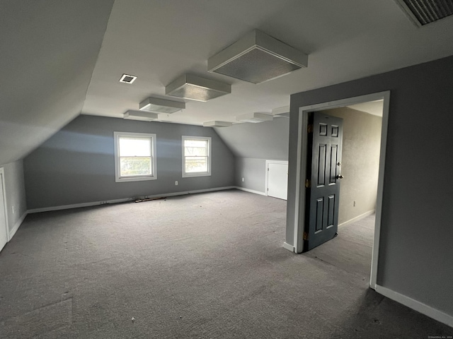 additional living space with carpet floors and vaulted ceiling