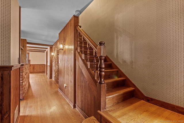 stairs featuring hardwood / wood-style flooring and wood walls