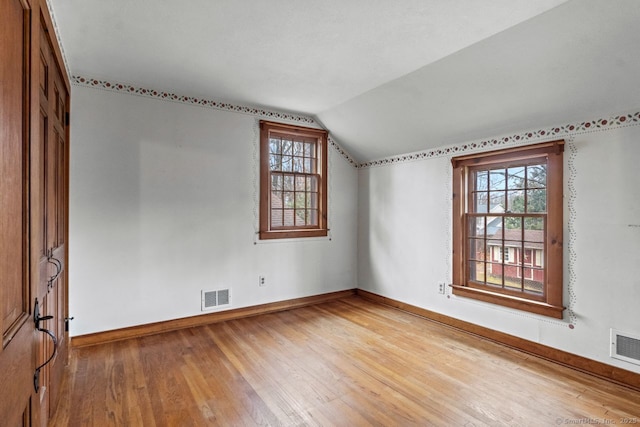 additional living space featuring hardwood / wood-style floors and lofted ceiling