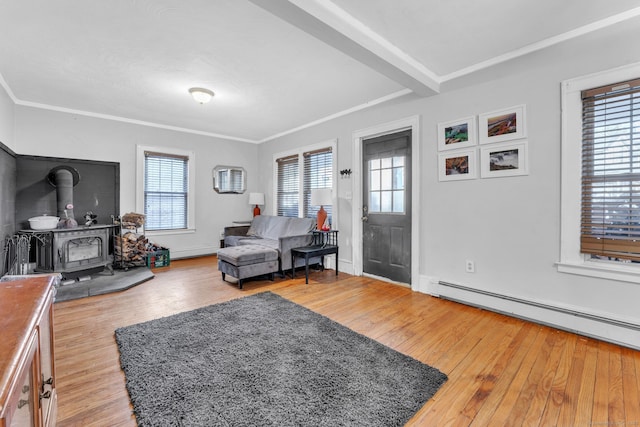 living room featuring ornamental molding, beam ceiling, a baseboard radiator, hardwood / wood-style floors, and a wood stove