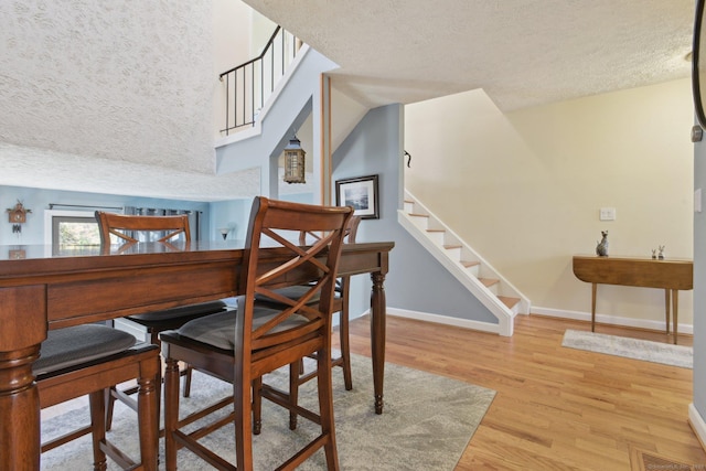 dining space featuring light hardwood / wood-style floors and a textured ceiling