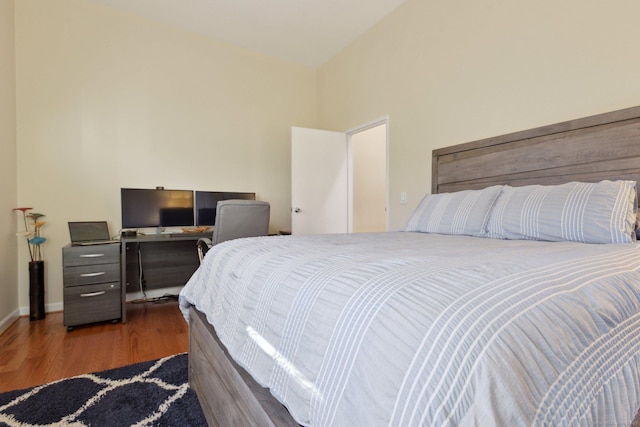 bedroom with dark hardwood / wood-style floors and lofted ceiling