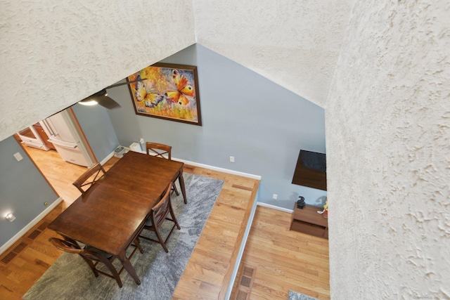 dining room with lofted ceiling, a textured ceiling, and hardwood / wood-style flooring