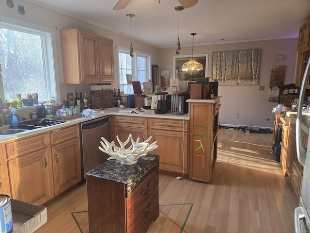 kitchen featuring pendant lighting, light wood-type flooring, stainless steel dishwasher, and sink