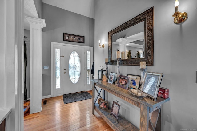 entrance foyer featuring ornate columns and light hardwood / wood-style flooring