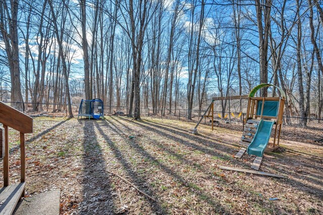 view of yard featuring a playground and a trampoline