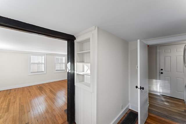 hallway with built in shelves and dark hardwood / wood-style floors