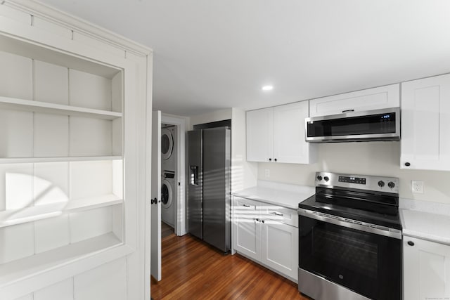 kitchen with white cabinetry, stacked washing maching and dryer, dark hardwood / wood-style flooring, built in features, and appliances with stainless steel finishes