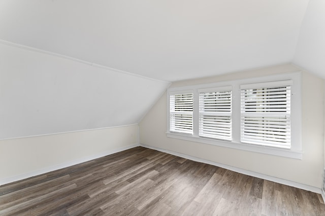 additional living space with dark hardwood / wood-style floors and vaulted ceiling