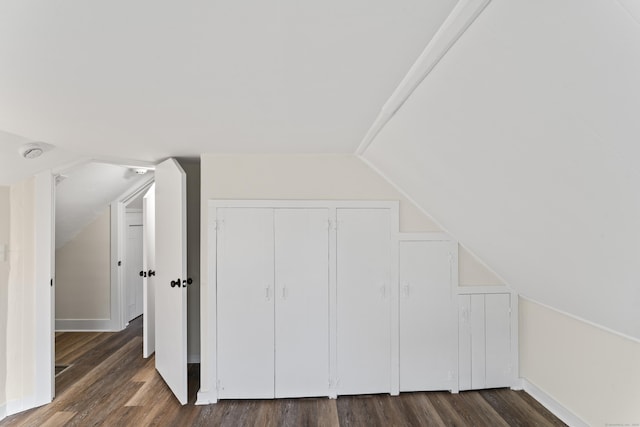 additional living space with dark wood-type flooring and lofted ceiling