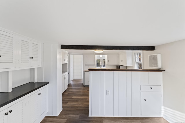 kitchen featuring dishwashing machine, white cabinetry, beamed ceiling, and dark wood-type flooring