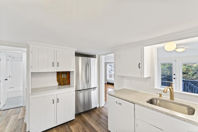 kitchen featuring white cabinetry, dishwasher, sink, dark hardwood / wood-style flooring, and stainless steel fridge