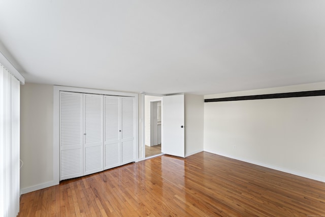 unfurnished bedroom featuring hardwood / wood-style floors and a closet