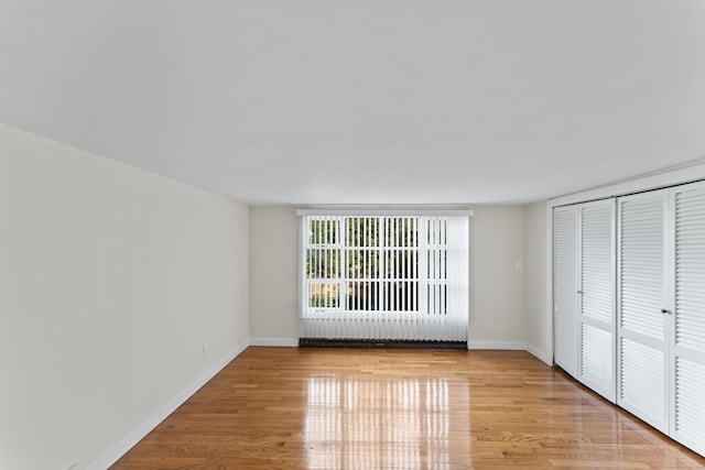 unfurnished bedroom with light hardwood / wood-style floors and a closet