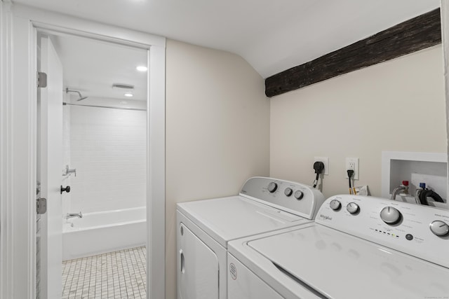 clothes washing area featuring washing machine and dryer and light tile patterned floors