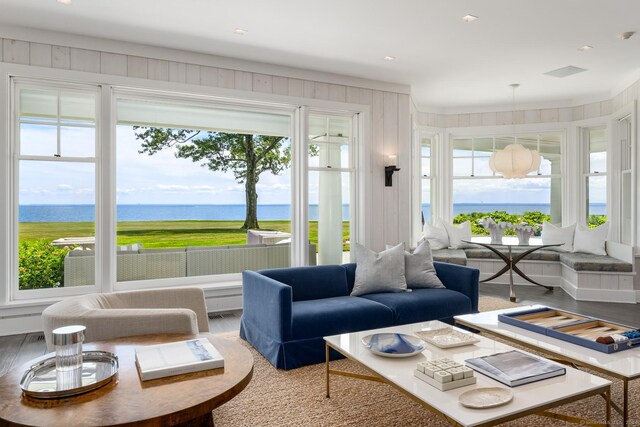 living room with a water view, hardwood / wood-style flooring, and a notable chandelier