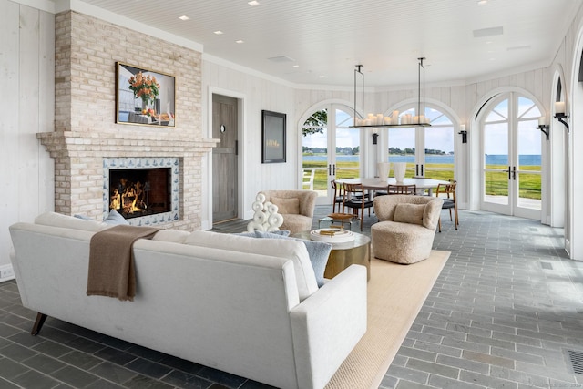 living room featuring plenty of natural light, a fireplace, ornamental molding, and recessed lighting