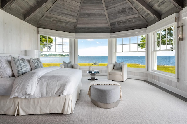 bedroom with vaulted ceiling with beams, a water view, wood walls, wooden ceiling, and baseboards