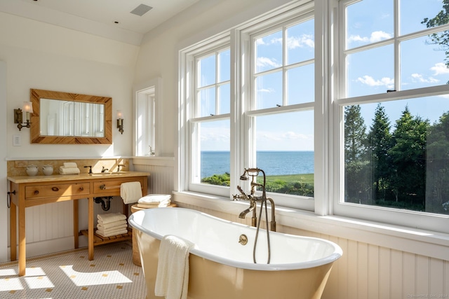 bathroom featuring a water view, a bathing tub, and sink