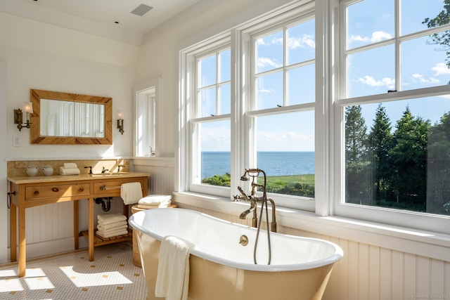 full bathroom featuring a wainscoted wall, a water view, vanity, and a freestanding bath