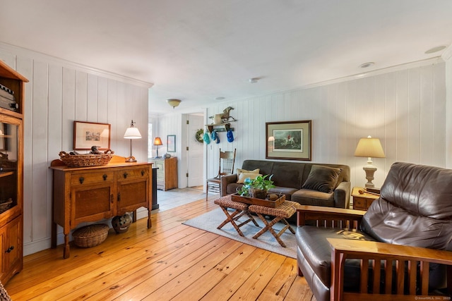 living room with crown molding and light wood-type flooring