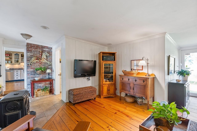 tiled living room with ornamental molding and a wood stove