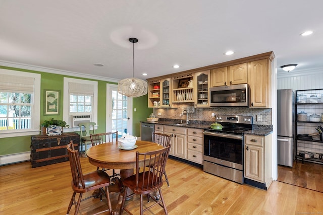 kitchen with sink, crown molding, pendant lighting, stainless steel appliances, and light hardwood / wood-style floors