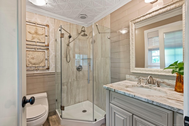 bathroom featuring ornamental molding, toilet, an enclosed shower, and vanity