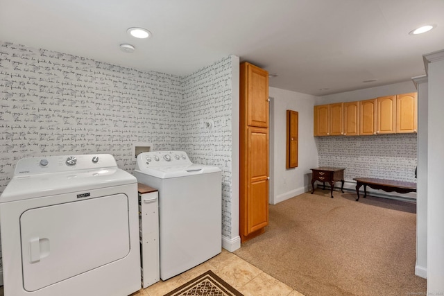 clothes washing area with cabinets, light colored carpet, and washer and dryer