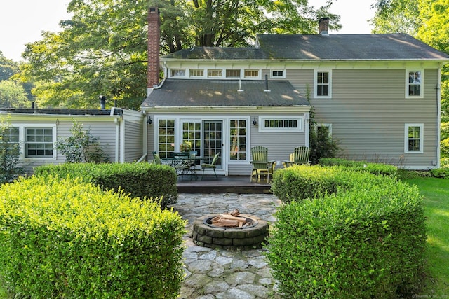 back of house featuring a wooden deck and an outdoor fire pit