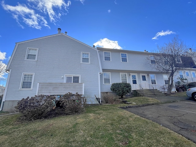 back of property featuring a lawn