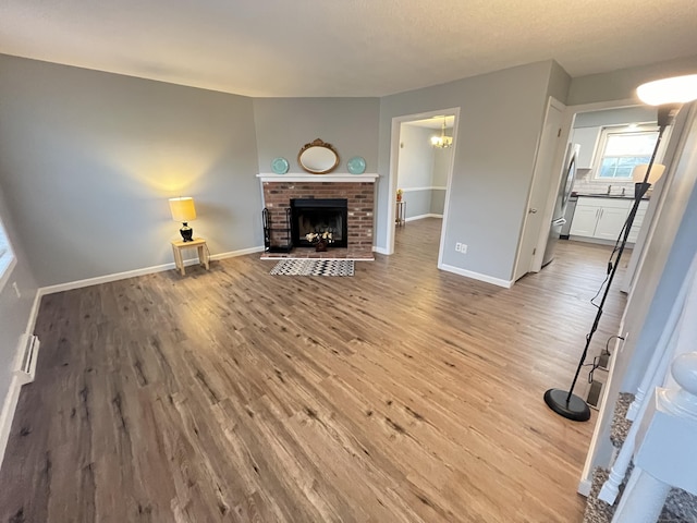 unfurnished living room with a fireplace, a textured ceiling, and light hardwood / wood-style flooring