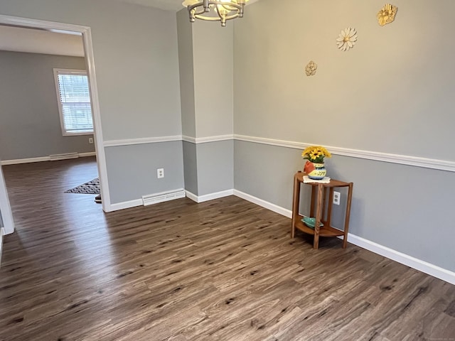 unfurnished room featuring dark hardwood / wood-style floors and an inviting chandelier