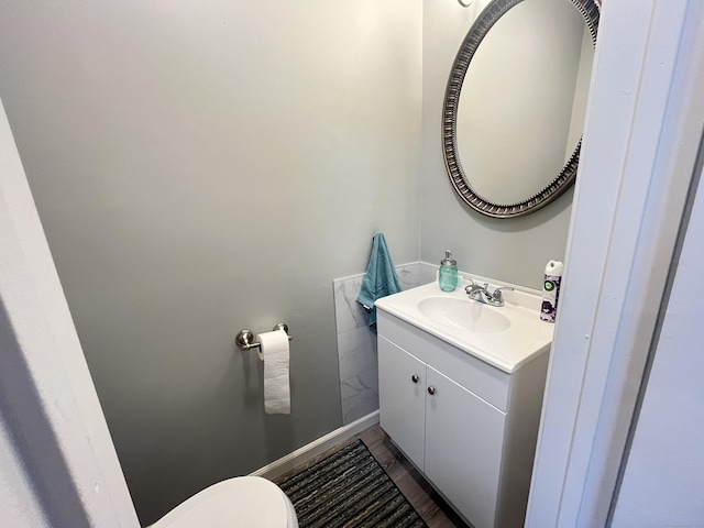 bathroom with hardwood / wood-style floors, vanity, and toilet