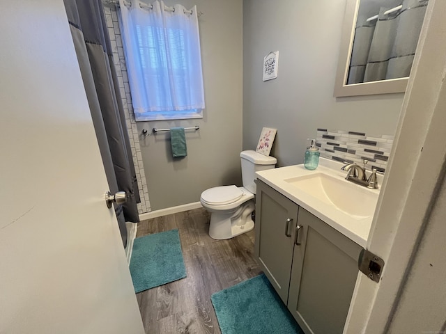 bathroom featuring decorative backsplash, a shower with curtain, vanity, hardwood / wood-style floors, and toilet