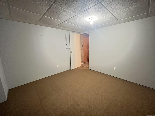 carpeted spare room featuring a drop ceiling