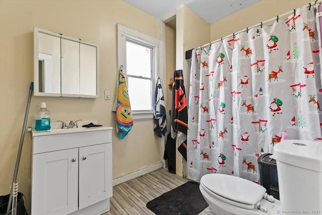 full bathroom featuring vanity, hardwood / wood-style flooring, toilet, and shower / tub combo with curtain