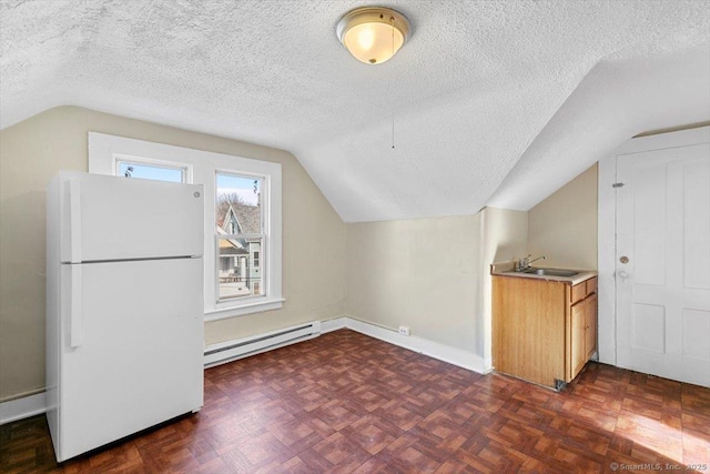 additional living space with lofted ceiling, dark parquet floors, sink, a textured ceiling, and baseboard heating