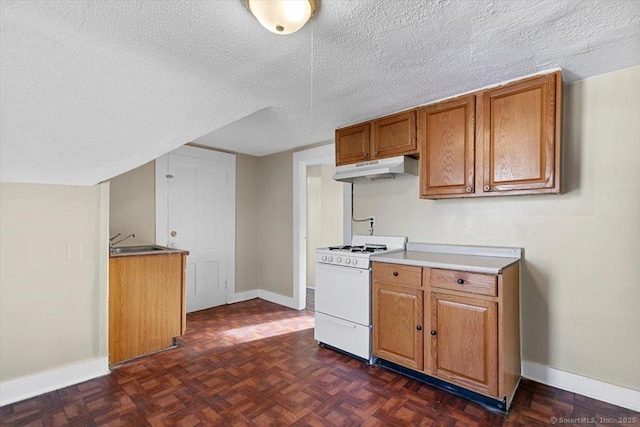 kitchen featuring a textured ceiling, dark parquet floors, white range oven, and sink